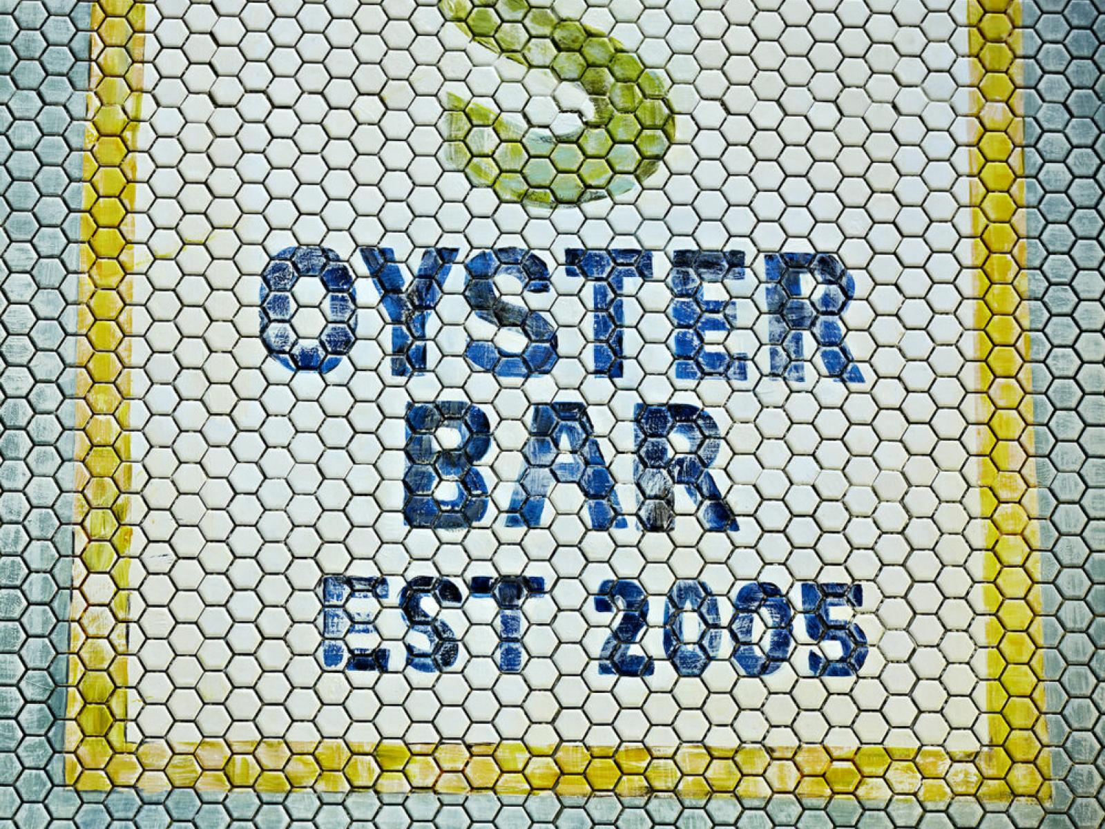 Tile mosaic with the words "Oyster Bar Est 2005" in white, blue, and yellow